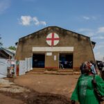View from the old Lita Hospital building, showing a woman walking toward the Ebola Traitment Center. Photo by Akilimali Chomachoma